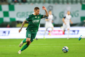 Soccer_ Player_ In_ Action_ On_ Field.jpg Wallpaper