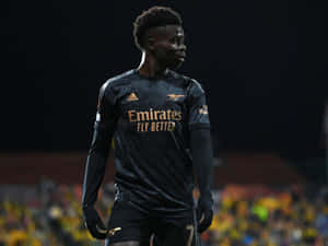 Soccer Player In Black Kit Night Game Wallpaper