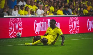 Soccer Player Seatedon Pitch Wallpaper