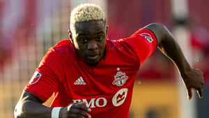 Soccer Playerin Action Red Uniform Wallpaper