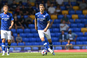 Soccer Playersin Blue Kit During Match Wallpaper