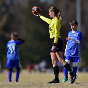 Soccer Referee Holding Ball During Match.jpg Wallpaper
