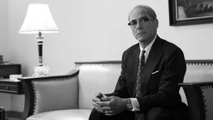 Solemn Man Seatedin Office Blackand White Wallpaper