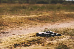 Solitary Revolver Resting On Rough Terrain Wallpaper