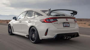 Sporty Hatchback On A Scenic Road Wallpaper