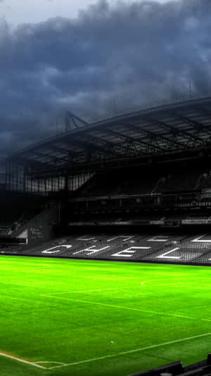 Stadium Silhouette Under Stormy Skies Wallpaper