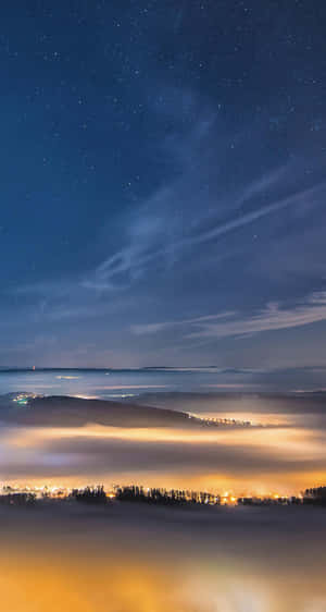 Starry Night Over Misty Landscape Wallpaper