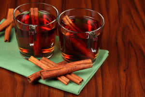 Steaming Hot Glass Of Mulled Wine With Spices And Oranges Wallpaper