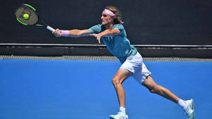 Stefanos Tsitsipas Reaching For Tennis Ball Wallpaper