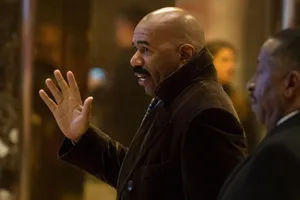 Steve Harvey Confidently Raising Hand During A Talk Wallpaper