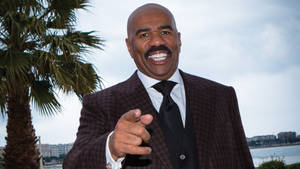 Steve Harvey Near A Palm Tree Wallpaper