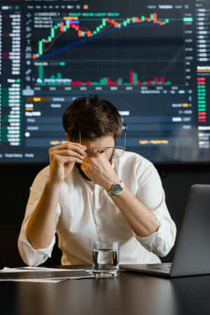 Stressed Trader In Front Of Stock Market Charts Wallpaper