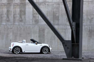 Striking Mini Roadster Accelerating On Open Road Wallpaper