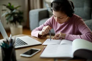 Studious Girl Wearing Headphones Wallpaper