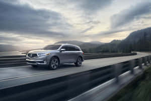 Stunning Acura Mdx In Motion On A Scenic Road Wallpaper