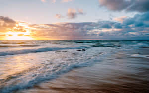 Stunning Beach Waves Rolling Onto The Shore Wallpaper