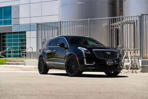 Stunning Black Cadillac Xt5 Parked On Urban Landscape Wallpaper