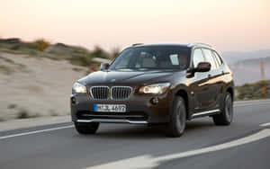 Stunning Bmw X1 Driving Through Scenic Landscape Wallpaper