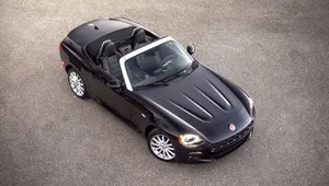 Stunning Fiat 124 Spider Cruising On Scenic Road Wallpaper