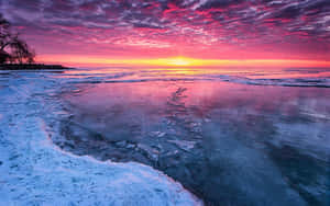 Stunning Frozen Lake Surrounded By Snow-capped Mountains Wallpaper