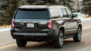 Stunning Gmc Yukon Driving Through A Picturesque Landscape Wallpaper