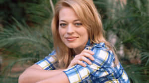 Stunning Jeri Ryan Posing Outdoors In A Stylish Attire Wallpaper