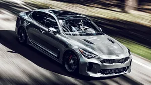 Stunning Kia Stinger In Vibrant Red On Scenic Road Wallpaper