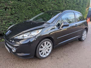 Stunning Peugeot 207 Gleaming Under The City Lights Wallpaper