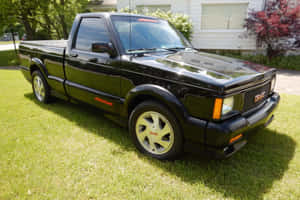 Stunning Red Gmc Syclone With Custom Wheels Parked Outdoors Wallpaper