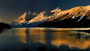 Stunning Sunrise Peaks Above Snow-capped Mountain Range Wallpaper