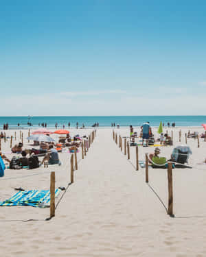 Stunning View Of The French Beach With Golden Sand And Blue Waves Wallpaper