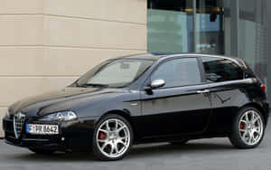 Stylish Alfa Romeo 147 Parked Outside Wallpaper