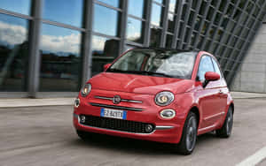 Stylish And Sleek Fiat Cinquecento Cruising On The Road Wallpaper