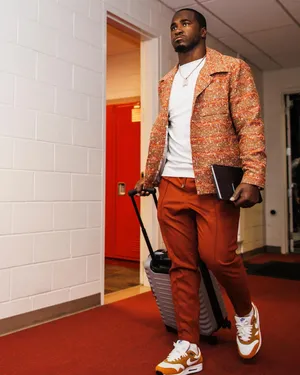 Stylish Athlete Walkingwith Luggage Wallpaper