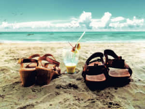 Stylish Beach Sandals On Sandy Shore Wallpaper