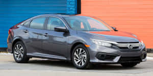 Stylish Compact Car Cruising On A Scenic Road Wallpaper