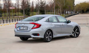 Stylish Compact Car In Motion Wallpaper