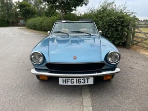 Stylish Fiat 124 Spider Cruising On The Road Wallpaper