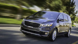 Stylish Kia Sedona Minivan On The Road Wallpaper