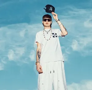 Stylish Man Holding Cap Against Blue Sky Wallpaper