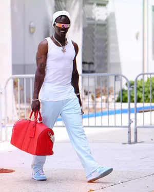 Stylish Man Walking With Red Bag Wallpaper