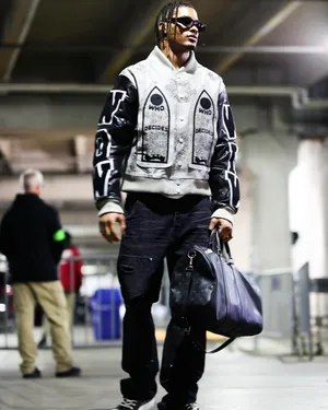 Stylish Man Walkingwith Duffle Bag Wallpaper