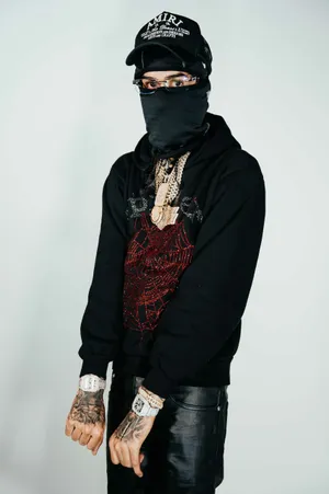 Stylish Manin Black Outfitwith Jewelryand Tattoos Wallpaper