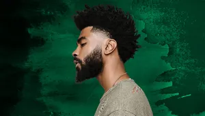 Stylish Manwith Curly Hairand Beard Wallpaper