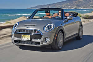 Stylish Mini Cooper Convertible Cruising On The Open Road Wallpaper