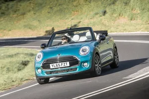 Stylish Mini Cooper Convertible Cruising On The Road Wallpaper