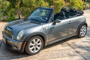 Stylish Mini Cooper S Convertible Cruising On The Open Road Wallpaper
