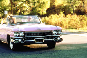 Stylish Pink Cadillac Parked Outdoors Wallpaper