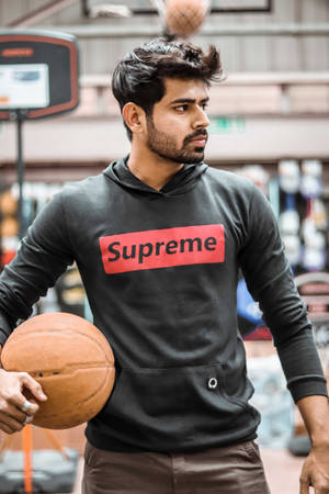 Stylish Player In Supreme Hoodie Holding Basketball Wallpaper