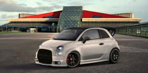 Stylish Red Fiat 500 Parked On City Street Wallpaper